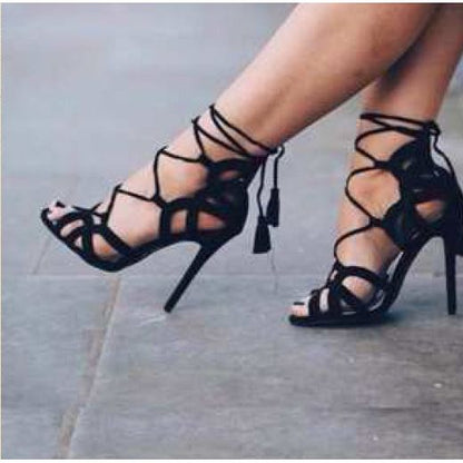 Black criss-cross strap heels with tassel accent. 